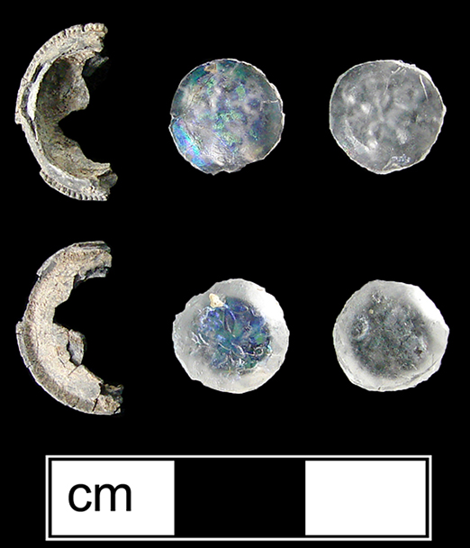 Pewter setting fragment with two surviving colorless insets molded with a floral pattern.
